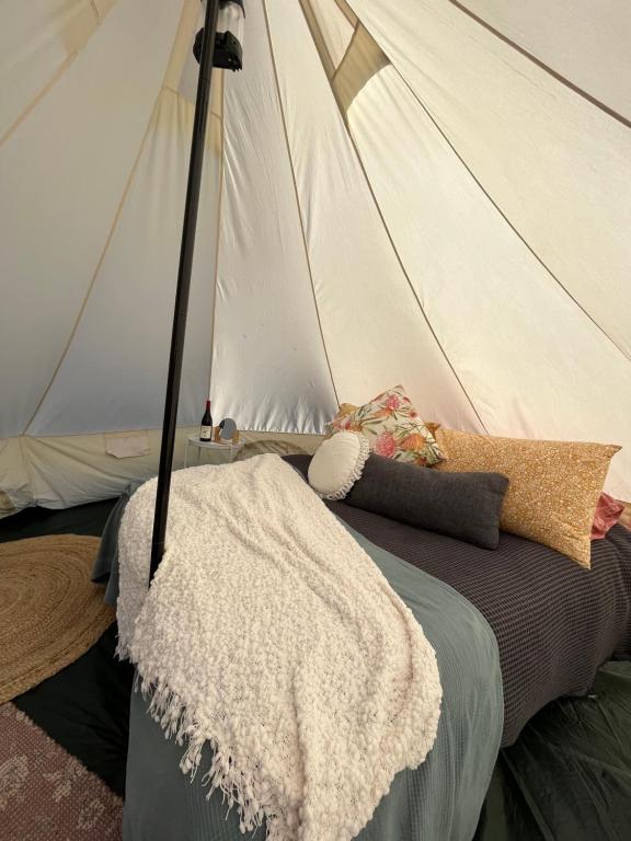 Ararat的住宿－Cosy Glamping Tent 3，一张带白色毯子的床和一个帐篷