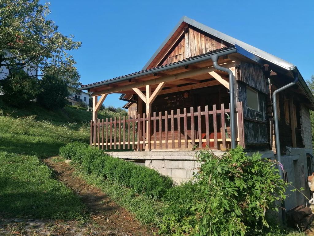 Cabaña de madera con porche y valla en Hiška ob gozdu, en Polzela