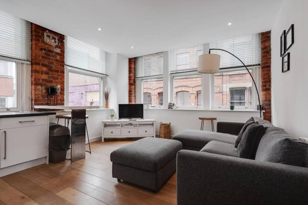 een woonkamer met een bank en een tafel bij GuestReady - Northern Quarter Urban Escape in Manchester
