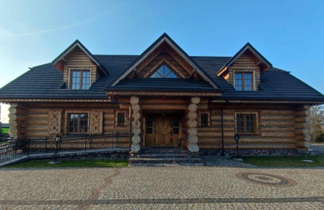 duży drewniany dom z dachem gambrel w obiekcie Chata Góralska i Pokoje Gościnne w Ciechocinku