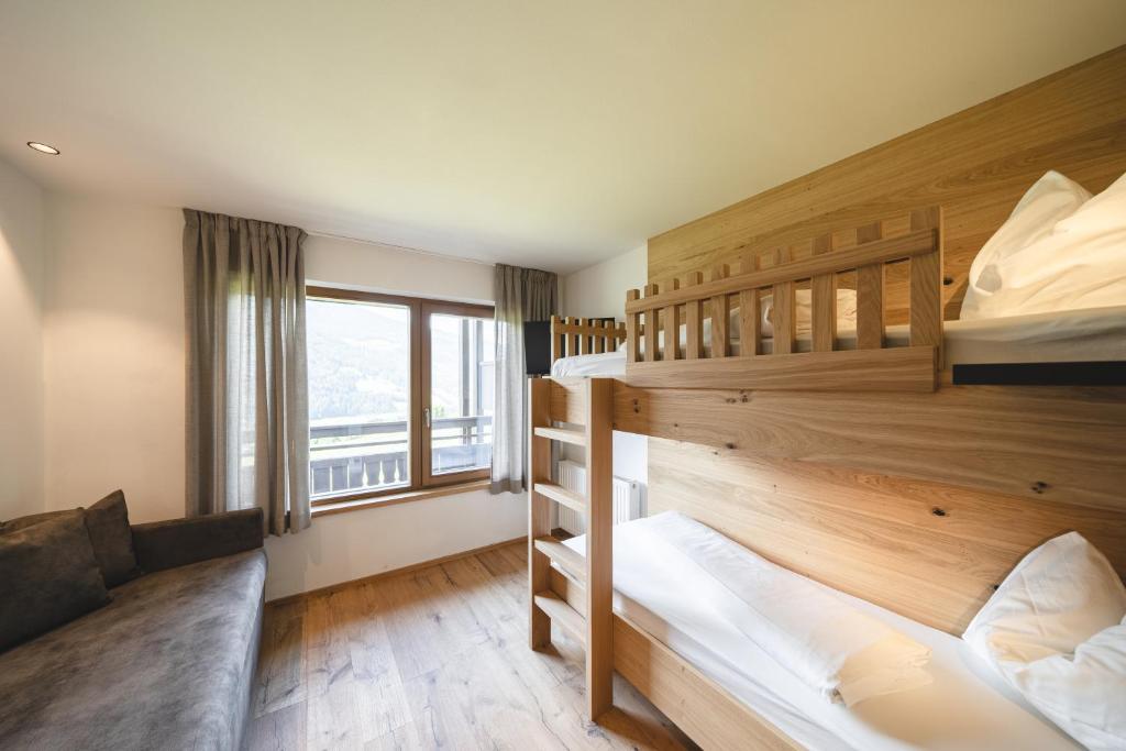 two bunk beds in a room with a window at Hotel Lahnerhof in Vipiteno