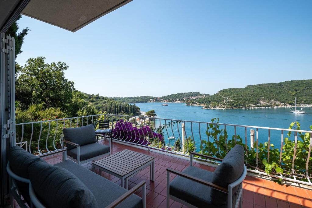 a balcony with chairs and a view of the water at Holiday Home Zaton in Dubrovnik