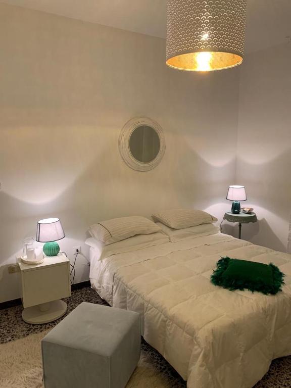 a bedroom with a large bed and two lamps at Casa della Piazza in CastellʼAlfero
