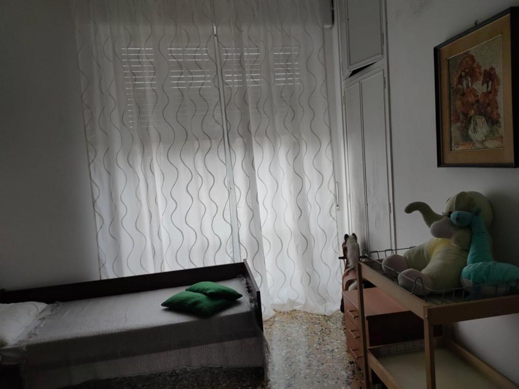 a bedroom with a bed and a window with a curtain at Casa della Piazza in CastellʼAlfero