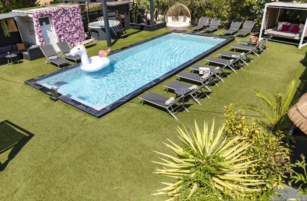 een zwembad met een zwaan in een tuin bij Hôtel Eden Cassis in Cassis