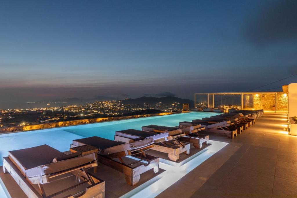 una piscina en la azotea de un edificio por la noche en Sunset Hill Suites en Mykonos