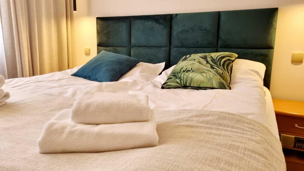a large white bed with two towels on it at Hotel Kama Park in Sieraków