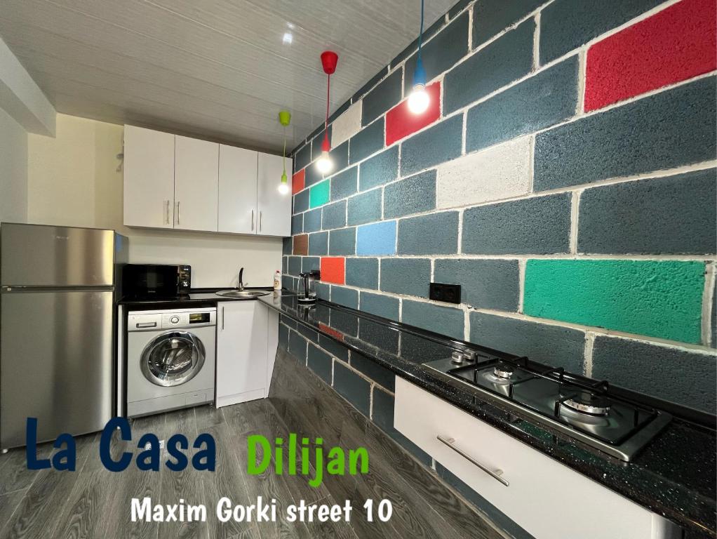 - une cuisine avec un mur en briques et un lave-linge dans l'établissement Hostel La Casa Dilijan, à Dilidjan