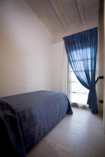 a bedroom with a blue bed and a window at Residence Alexandra Stay in Sirmione