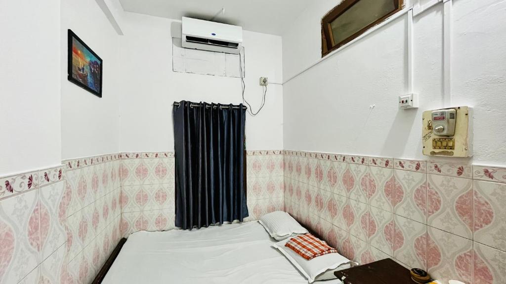 een kleine kamer met een bed en verwarming bij The Equinox Hotel in Bongaigaon