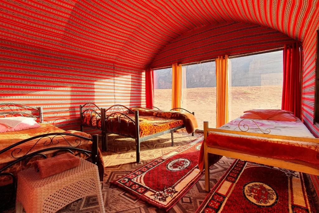 a room with beds in a room with a window at Welcome to Wadi Rum Camp in Wadi Rum