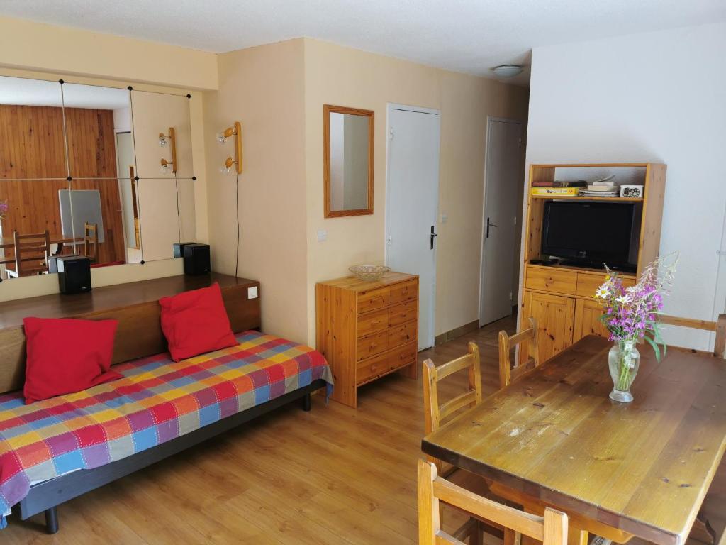 ein Wohnzimmer mit einem Sofa und einem Tisch in der Unterkunft Appartement Vars les Claux 4/5 personnes in Vars