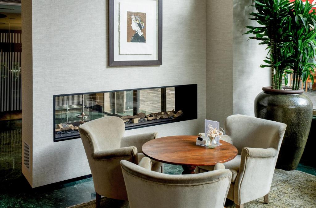 a living room with a table and chairs and a fireplace at Melia Plaza Valencia in Valencia