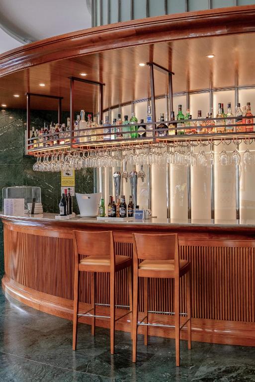 a bar with chairs and glasses on the wall at Melia Plaza Valencia in Valencia