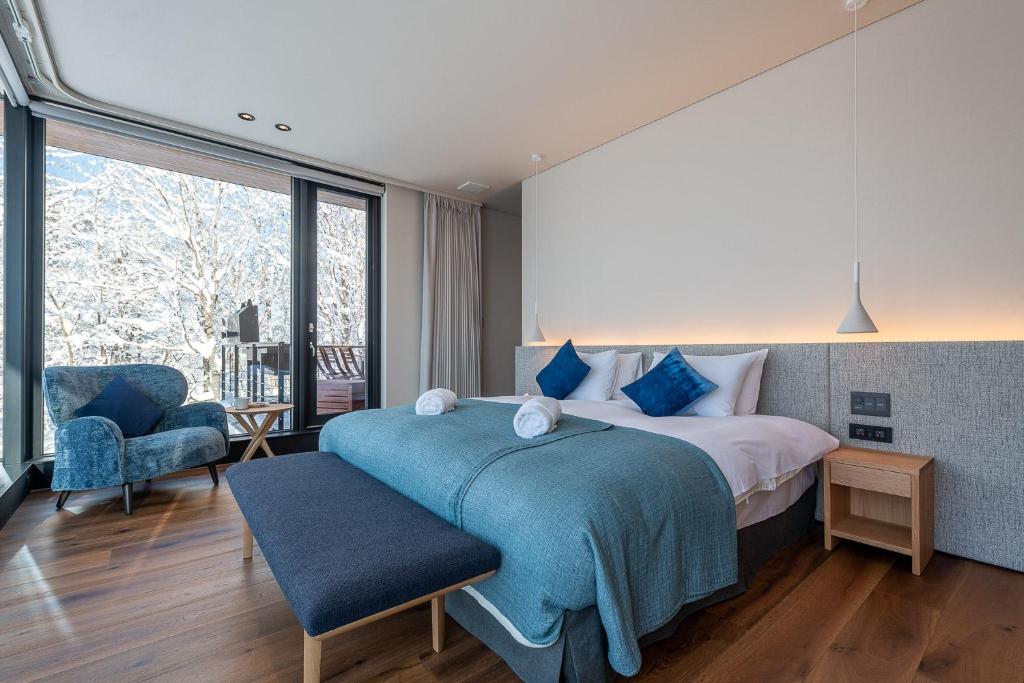 a bedroom with a bed and a large window at Sena 惺絆 in Niseko