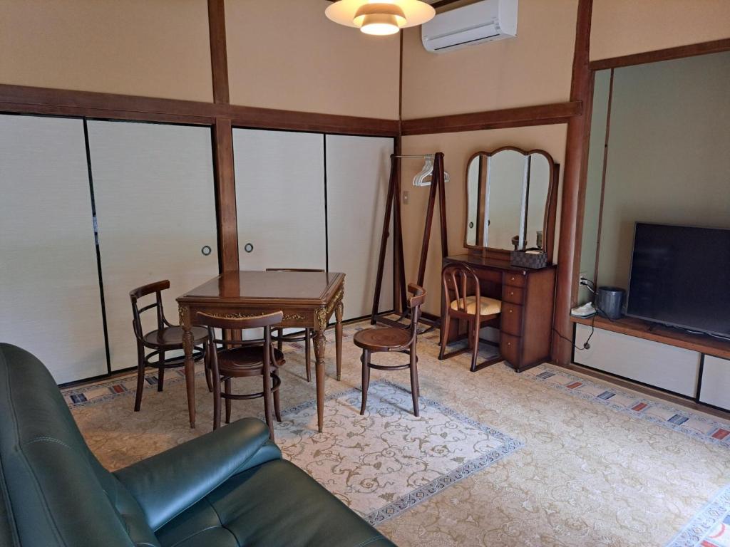 館山市にあるFormer Residence Vacation Rental Minamijuan - Vacation STAY 57751vのソファとテーブルとテレビのあるリビングルーム