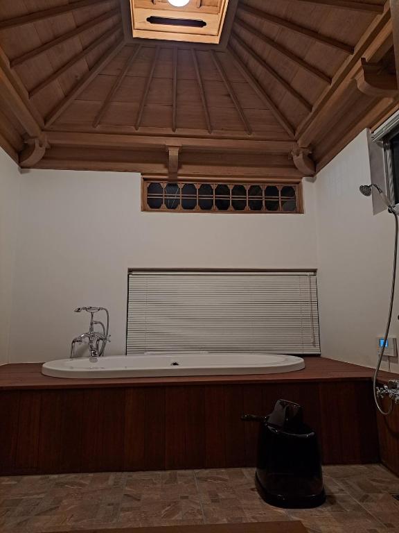 館山市にあるFormer Residence Vacation Rental Minamijuan - Vacation STAY 57751vの木製の天井の客室で、バスタブが備わります。