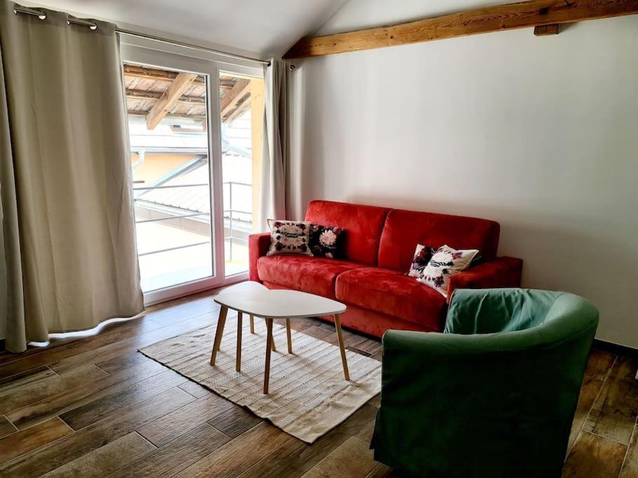 ブロッツハイムにあるAppartement Proche Aéroport Bâle/Mulhouseの赤いソファとテーブルのあるリビングルーム