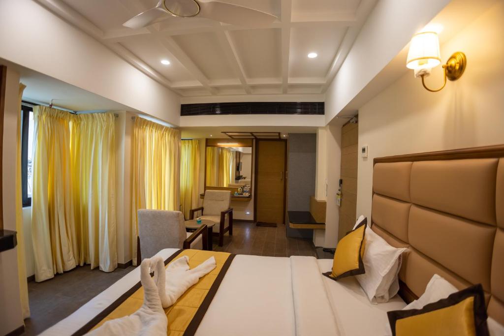 um quarto de hotel com uma cama e uma sala de estar em Hotel Grand Sabarees em Madurai