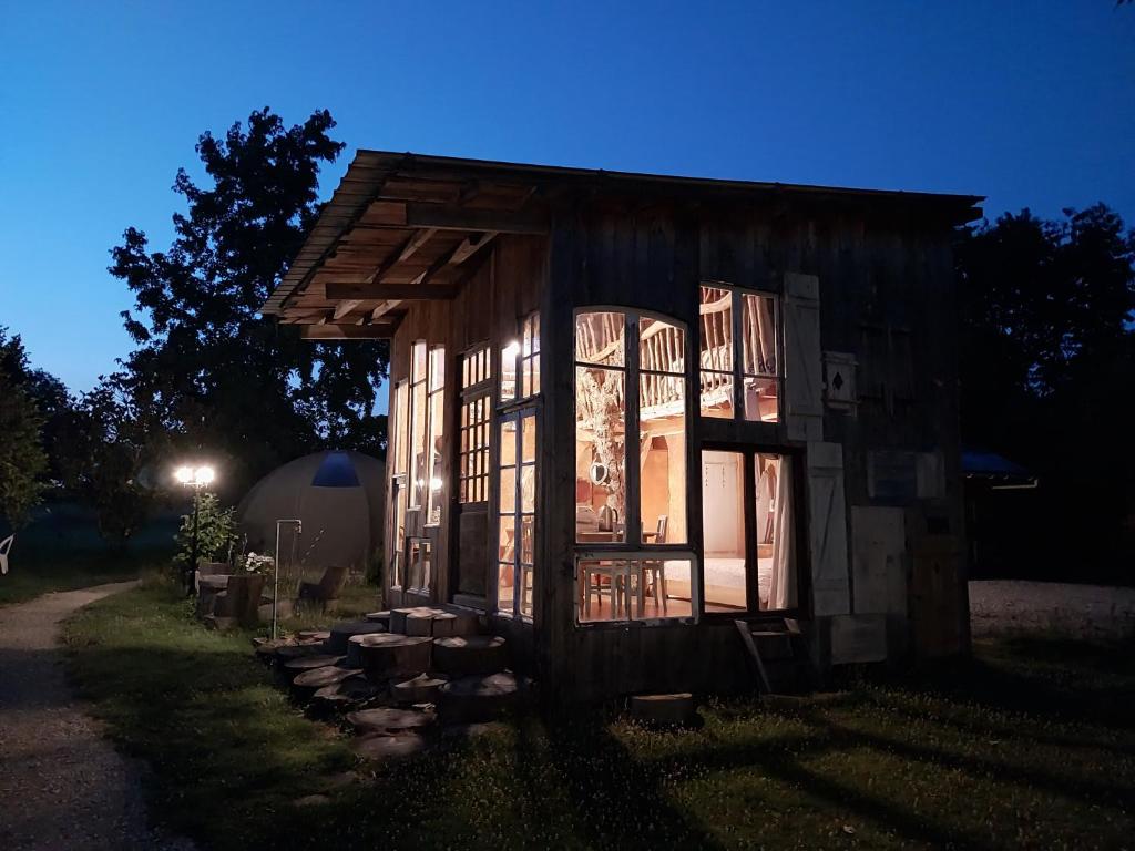 a small wooden house with the lights on at La chouette étoilée in Auxon