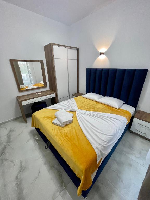 a bedroom with a large bed with a blue headboard at Bora Lindi Ulcinj apartments in Ulcinj