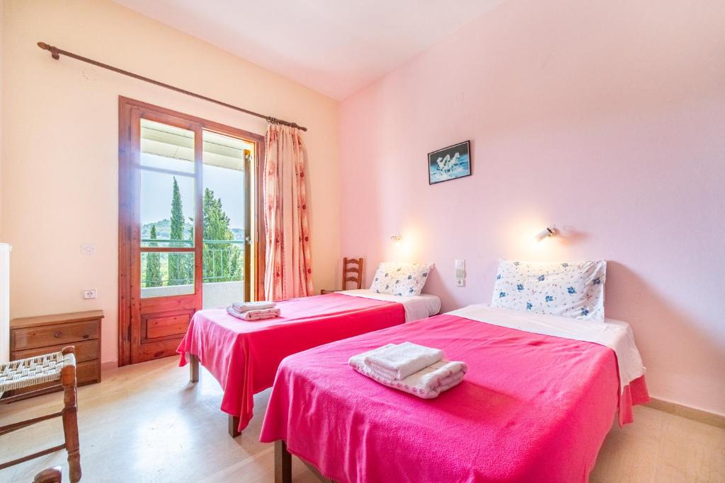 dwa łóżka w pokoju z oknem w obiekcie Mercury apartment 4 w mieście Peroulades