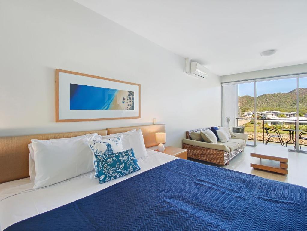 a bedroom with a large bed with a blue blanket at Blue on Blue Studio Room 1322 in Nelly Bay