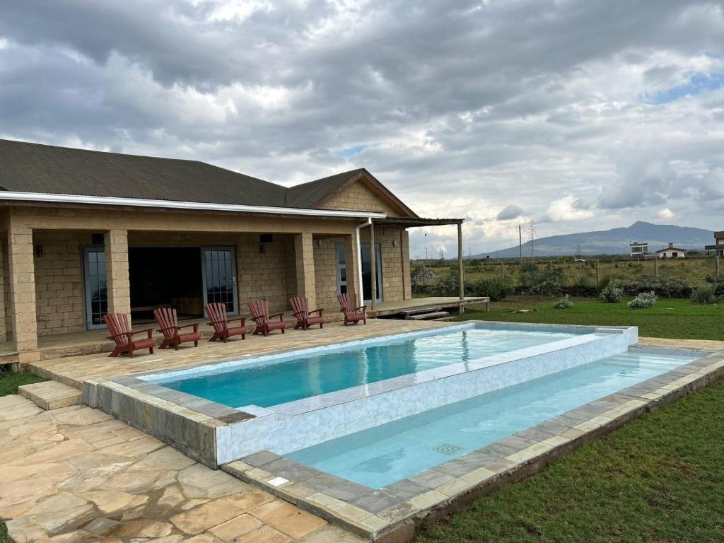 a swimming pool in front of a house at Naivasha 4-Bedroom All Ensuite Cottage in Naivasha