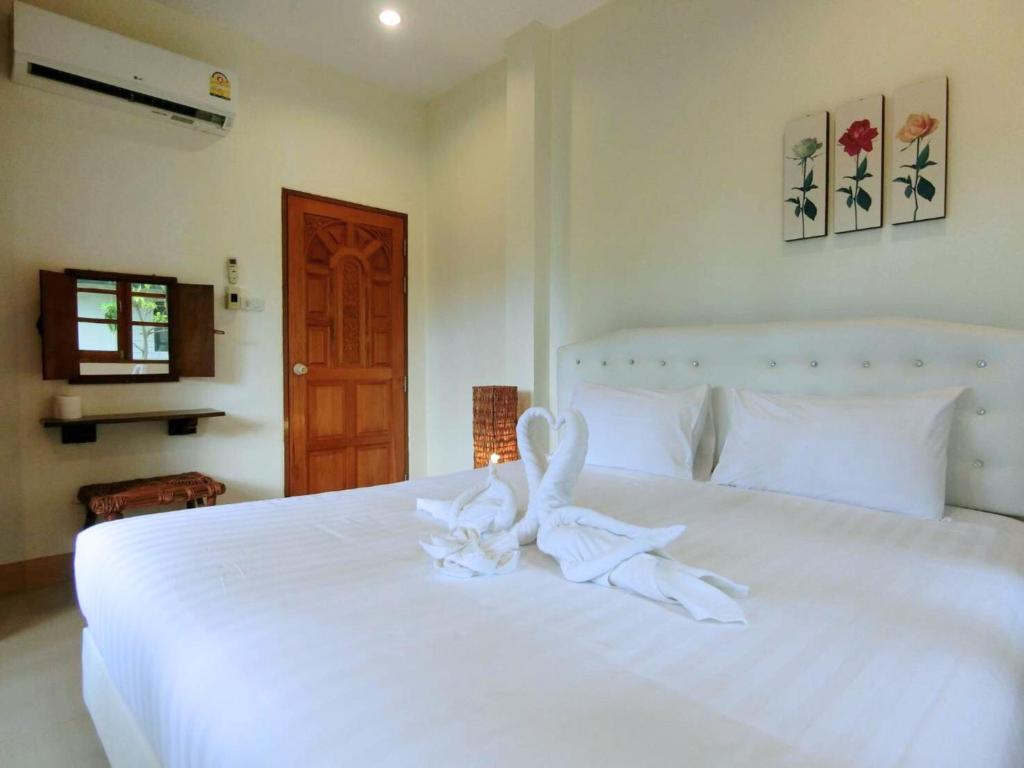 Ban Thung Sam SaoにあるAURA Park Resortの白い花の白いベッド