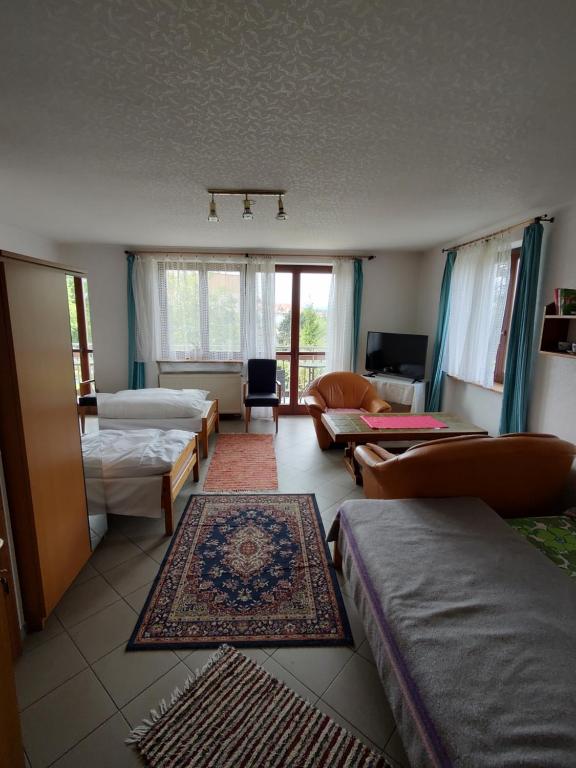 a room with beds and a living room with a couch at Pension Nela in Klatovy