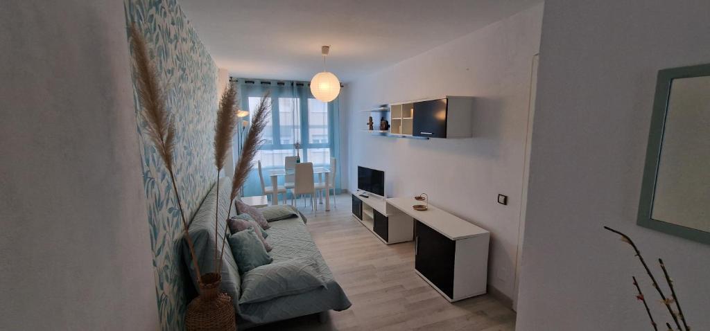 a living room with a couch and a television at Azulverde de Mar - En 1ª línea Playa San Lorenzo in Gijón