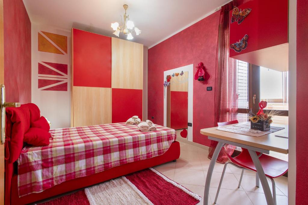 Dormitorio rojo con cama y escritorio en Il Risveglio, en Codrongianos