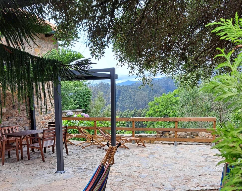 eine Terrasse mit einem Tisch und Stühlen sowie Aussicht in der Unterkunft Casa da Oliveira in Cariño