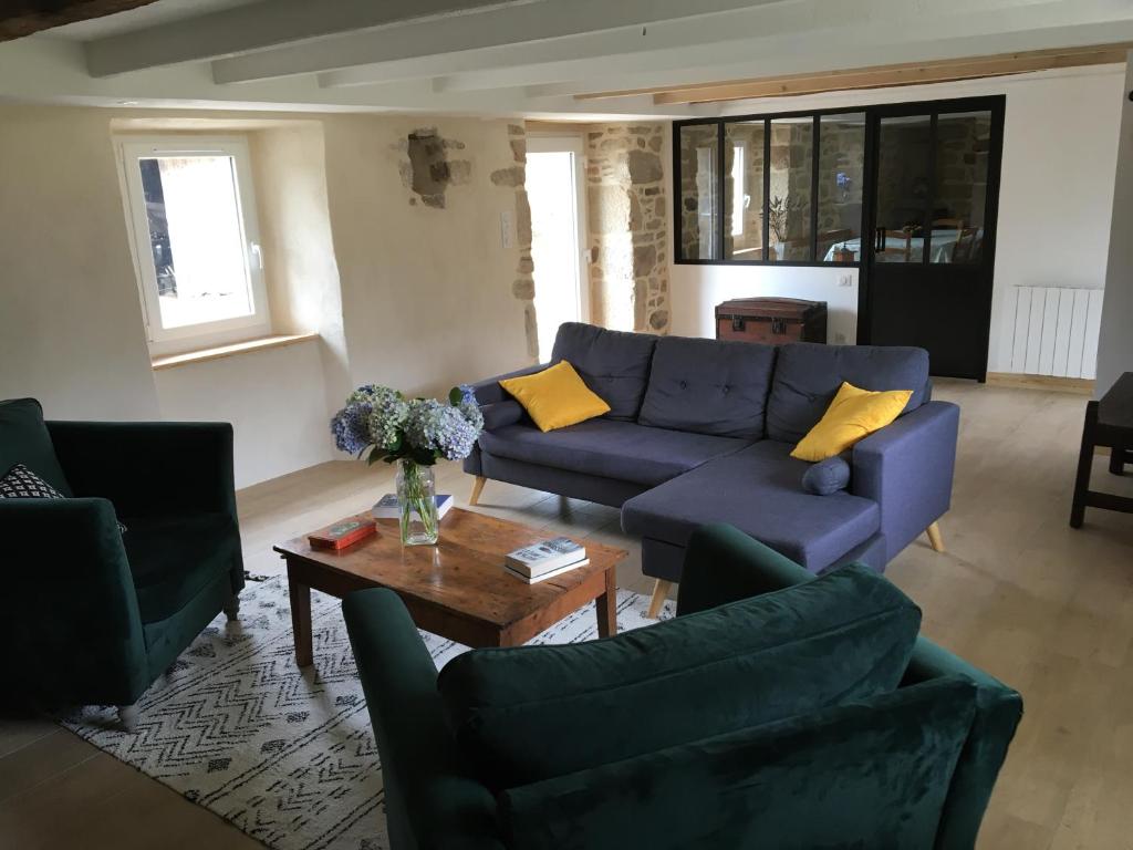 un soggiorno con divani blu e tavolino da caffè di La maison de Gwen a Cléden-Cap-Sizun