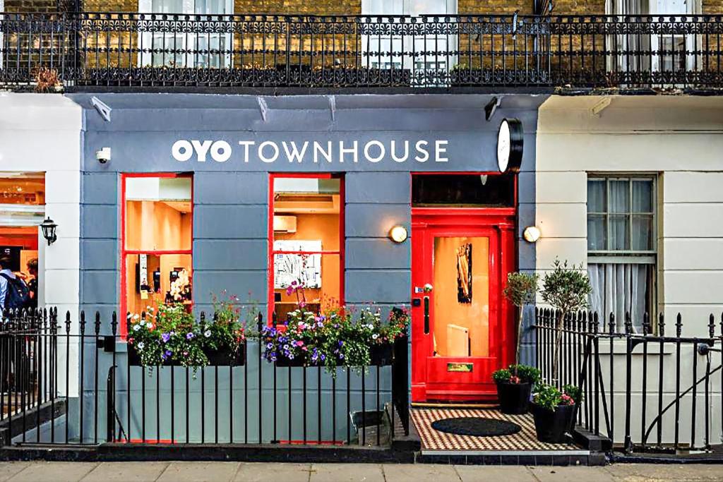 una porta rossa di una casa a schiera di Oxo di OYO Townhouse 30 Sussex Hotel, London Paddington a Londra