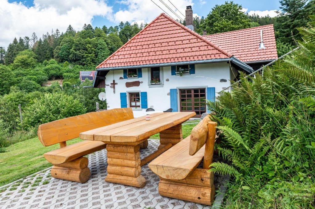 a wooden picnic table and bench in front of a house at Ferien Alm Alfret in Herrischried