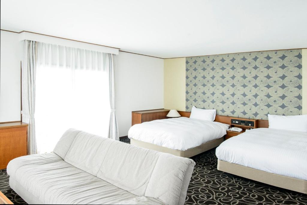 Postel nebo postele na pokoji v ubytování Suikouen Hotel