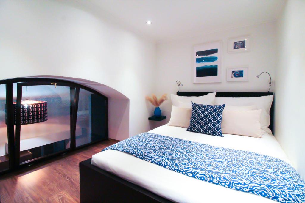 a bedroom with a large bed with blue and white pillows at Budapest Downtown Museum Apartments in Budapest