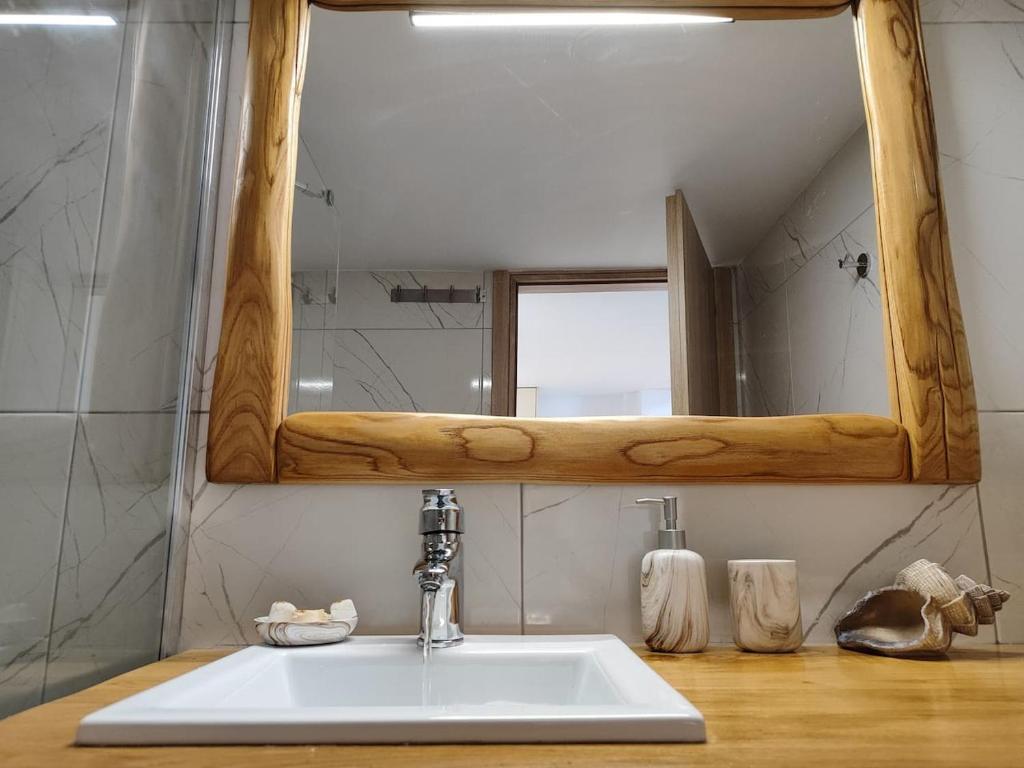 a bathroom with a white sink and a mirror at Isidora Apartments in Zagora