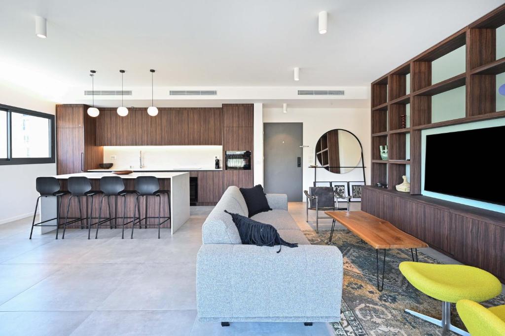 a living room with a couch and a tv at Modern 3BR retreat in the Old North by HolyGuest in Tel Aviv