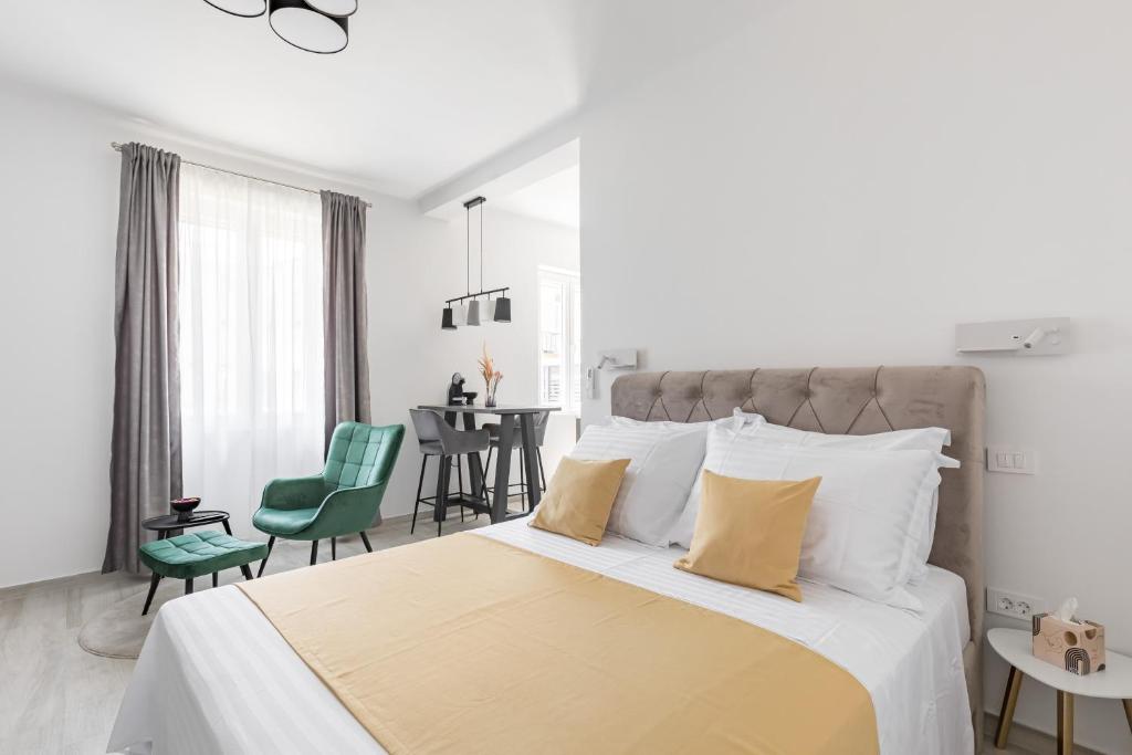 a white bedroom with a large bed with yellow pillows at Studio apartment Home in Split