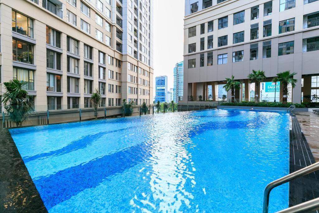 a large blue swimming pool in the middle of two buildings at Saigon Royal Apartment in Ho Chi Minh City