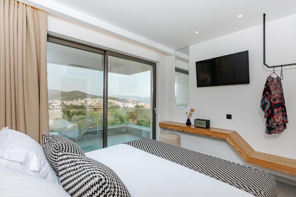 a bedroom with a bed and a large window at OPSIS Suites in Limenaria