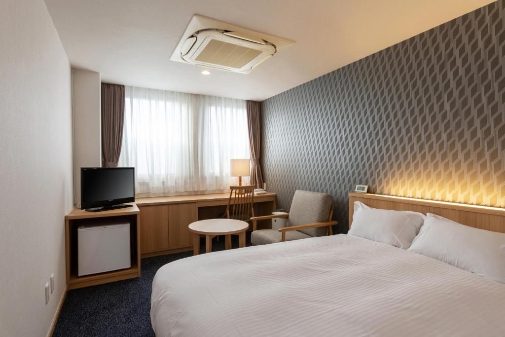 Postel nebo postele na pokoji v ubytování Suikouen Hotel