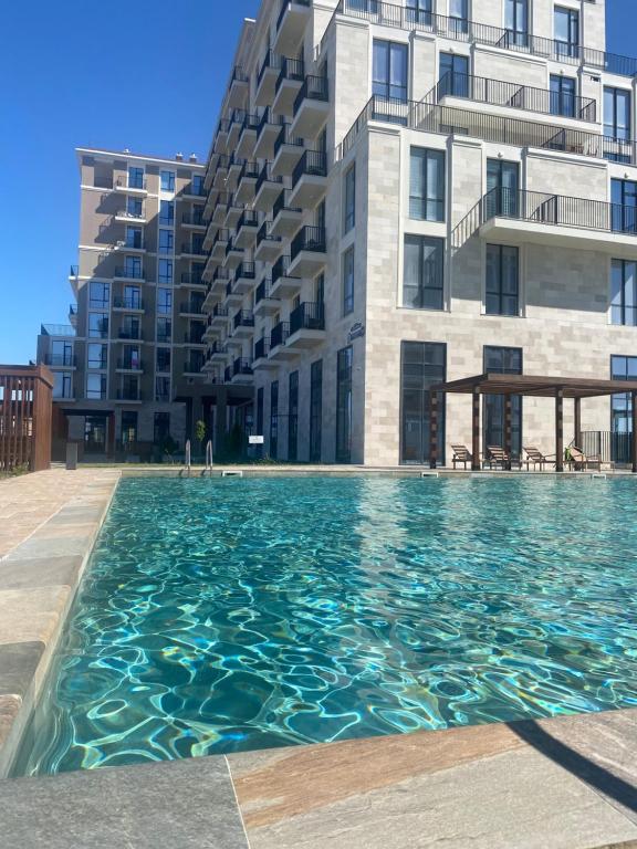 a swimming pool in front of a building at Aktau Riviera in Aktau