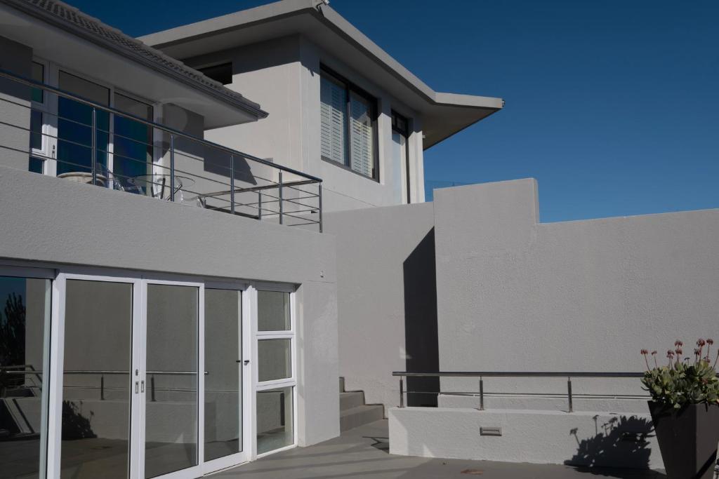 a white house with a large glass door at The Atlantic DonReal Guesthouse in Cape Town