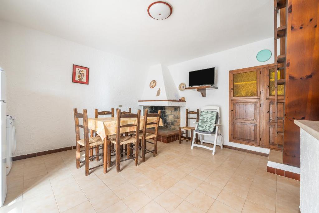 uma cozinha e sala de jantar com mesa e cadeiras em Spiaggia Grande Junior em Calasetta