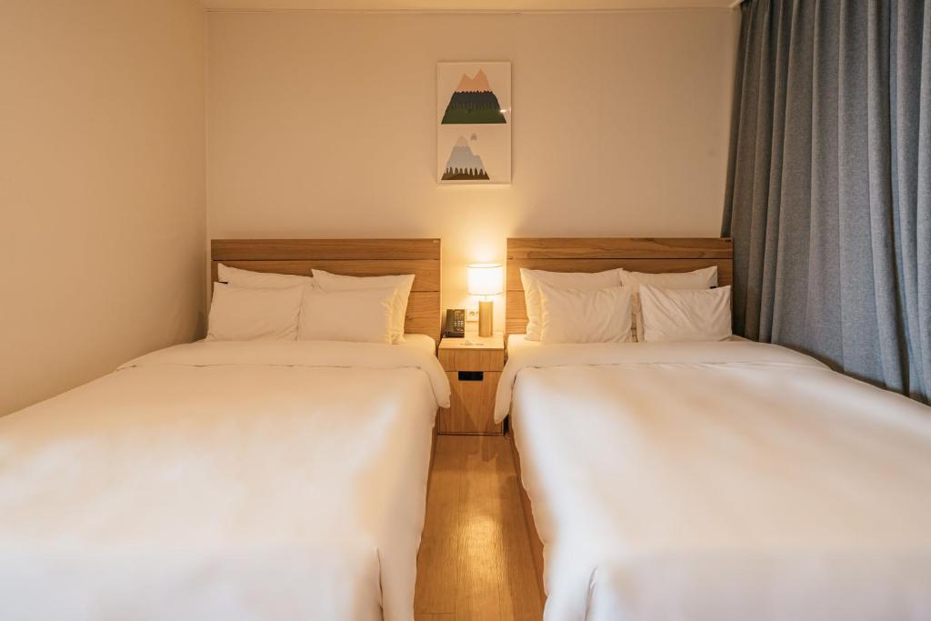 Postel nebo postele na pokoji v ubytování Heyy Seogwipo Hotel