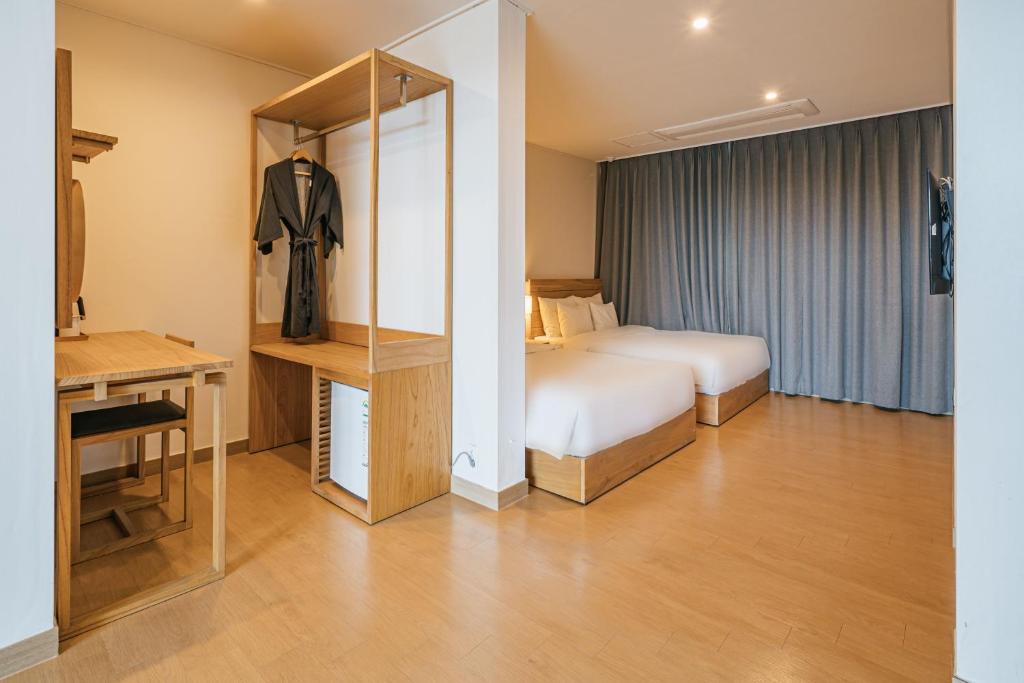 Postel nebo postele na pokoji v ubytování Heyy Seogwipo Hotel