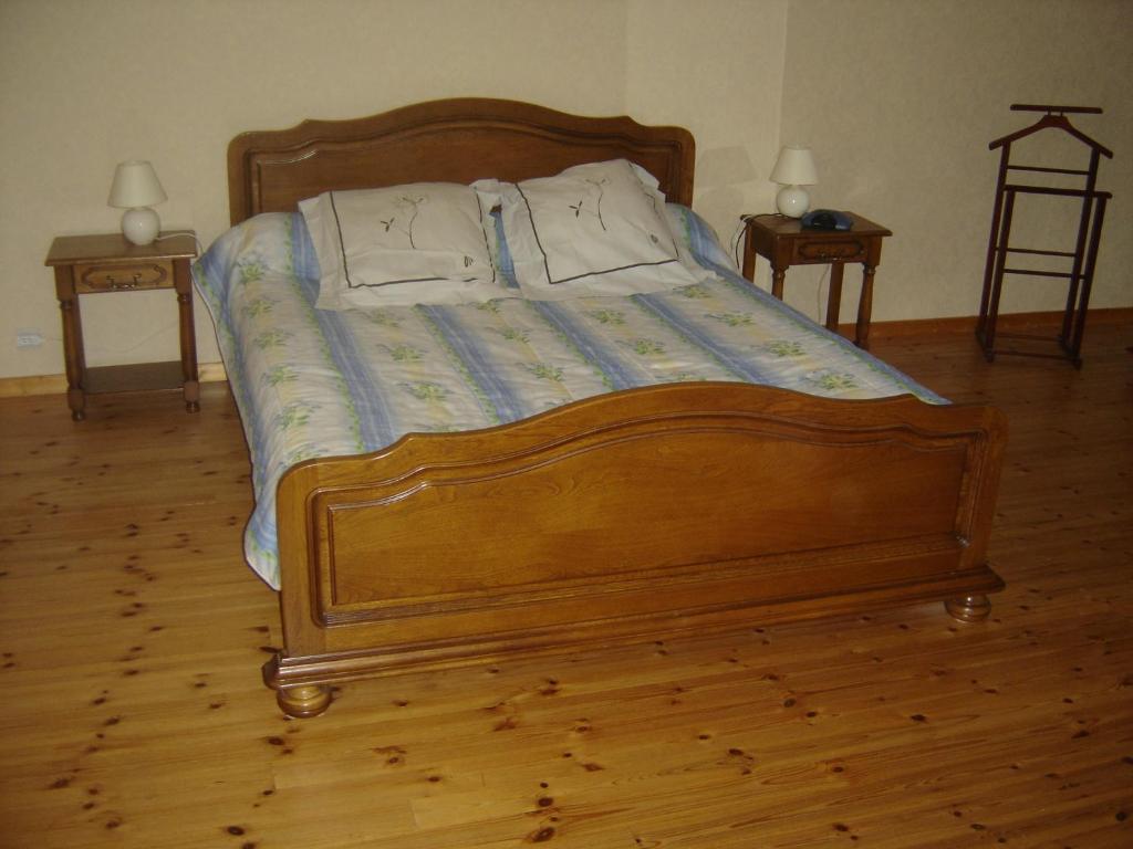 een bed met een houten frame in een slaapkamer bij Château Laborde Caudalie in Saint-Médard-de-Guizières